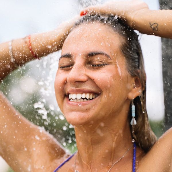 Person smiling and stretching outdoors, feeling refreshed and full of life.